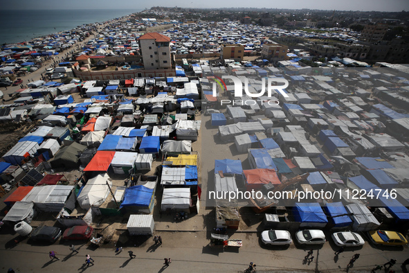 Tents housing internally displaced Palestinians are crowding the beach and the Mediterranean shoreline in Deir el-Balah in the central Gaza...