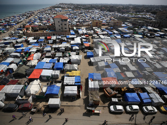 Tents housing internally displaced Palestinians are crowding the beach and the Mediterranean shoreline in Deir el-Balah in the central Gaza...