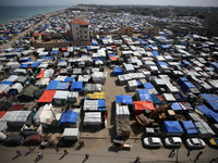 Tents housing internally displaced Palestinians are crowding the beach and the Mediterranean shoreline in Deir el-Balah in the central Gaza...