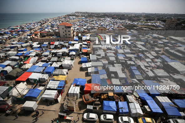 Tents housing internally displaced Palestinians are crowding the beach and the Mediterranean shoreline in Deir el-Balah in the central Gaza...