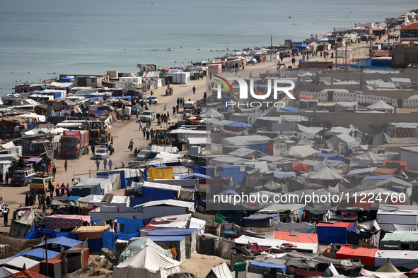 Tents housing internally displaced Palestinians are crowding the beach and the Mediterranean shoreline in Deir el-Balah in the central Gaza...