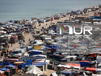 Tents housing internally displaced Palestinians are crowding the beach and the Mediterranean shoreline in Deir el-Balah in the central Gaza...