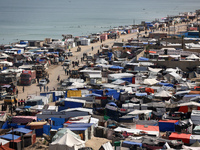 Tents housing internally displaced Palestinians are crowding the beach and the Mediterranean shoreline in Deir el-Balah in the central Gaza...