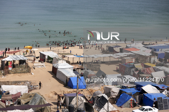 Tents housing internally displaced Palestinians are crowding the beach and the Mediterranean shoreline in Deir el-Balah in the central Gaza...