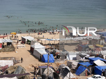 Tents housing internally displaced Palestinians are crowding the beach and the Mediterranean shoreline in Deir el-Balah in the central Gaza...