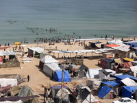 Tents housing internally displaced Palestinians are crowding the beach and the Mediterranean shoreline in Deir el-Balah in the central Gaza...