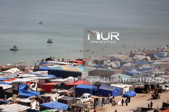 Tents housing internally displaced Palestinians are crowding the beach and the Mediterranean shoreline in Deir el-Balah in the central Gaza...