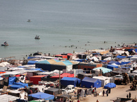 Tents housing internally displaced Palestinians are crowding the beach and the Mediterranean shoreline in Deir el-Balah in the central Gaza...