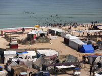 Tents housing internally displaced Palestinians are crowding the beach and the Mediterranean shoreline in Deir el-Balah in the central Gaza...