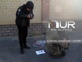 A serviceman and a police officer are collecting evidence after a Russian missile attack in Kharkiv, northeastern Ukraine, on May 10, 2024....