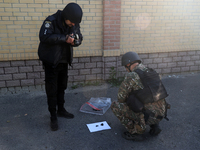 A serviceman and a police officer are collecting evidence after a Russian missile attack in Kharkiv, northeastern Ukraine, on May 10, 2024....