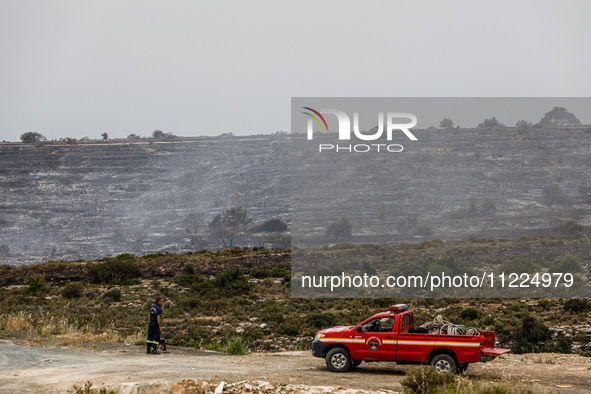 Members of the fire department are preparing a drone to inspect the area for any resurgence of the wildfire in Limassol, Cyprus, on May 10,...