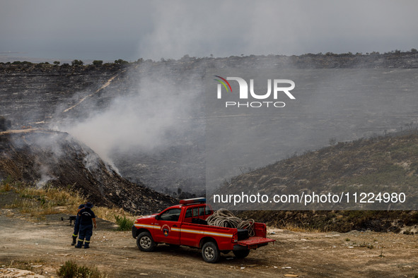 Members of the fire department are preparing a drone to inspect the area for any resurgence of the wildfire in Limassol, Cyprus, on May 10,...