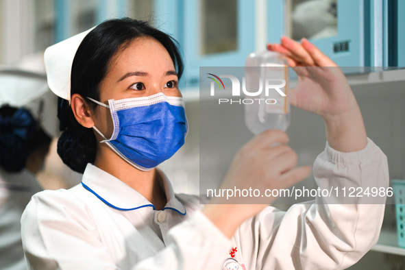 A nurse is checking liquid medicine at the otolaryngology department of Jiangxi Children's Hospital in Nanchang, Jiangxi Province, China, on...