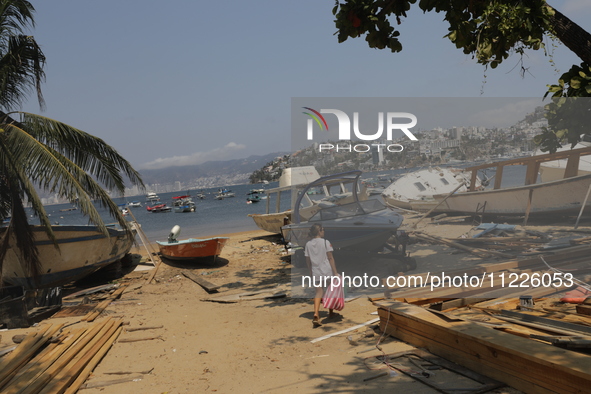 A person is walking between destroyed boats on the shore of Tamarindos Beach in Acapulco, Mexico, on April 17, 2024, six months after Hurric...