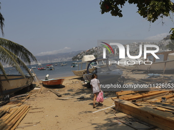 A person is walking between destroyed boats on the shore of Tamarindos Beach in Acapulco, Mexico, on April 17, 2024, six months after Hurric...