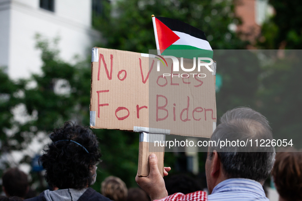 A demonstrator carries a sign in opposing President Joe Biden's re-election during a rally at the site of the George Washington university G...