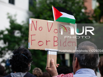 A demonstrator carries a sign in opposing President Joe Biden's re-election during a rally at the site of the George Washington university G...