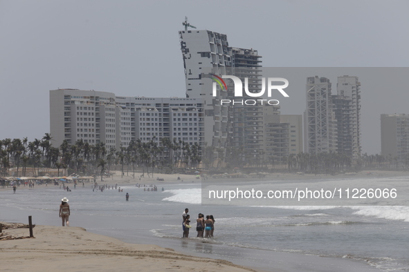 Tourists are enjoying the beach while hotels appear destroyed at Riviera Punta Diamante in Acapulco, Guerrero, six months after Hurricane Ot...