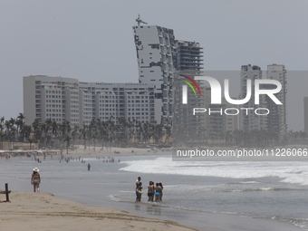 Tourists are enjoying the beach while hotels appear destroyed at Riviera Punta Diamante in Acapulco, Guerrero, six months after Hurricane Ot...