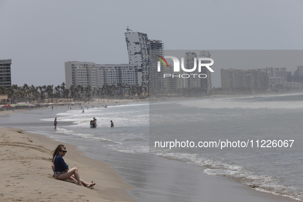 Tourists are enjoying the beach while hotels appear destroyed at Riviera Punta Diamante in Acapulco, Guerrero, six months after Hurricane Ot...