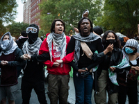 Pro-Palestinian students and their supporters form a protective chain around a temporary Gaza solidarity encampment outside the office of Ge...