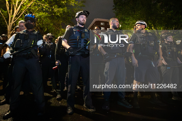 DC police with batons in hand prepare to arrest students for trespassing on George Washington University property, Washington, DC, May 9, 20...