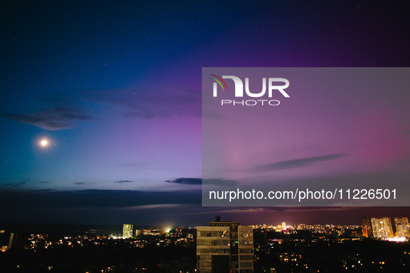 The moon is being illuminated by light reflected from the Earth and is surrounded by the northern lights, in Kharkiv, Ukraine, on May 10, 20...