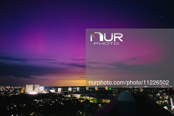 The moon is being illuminated by light reflected from the Earth and is surrounded by the northern lights, in Kharkiv, Ukraine, on May 10, 20...