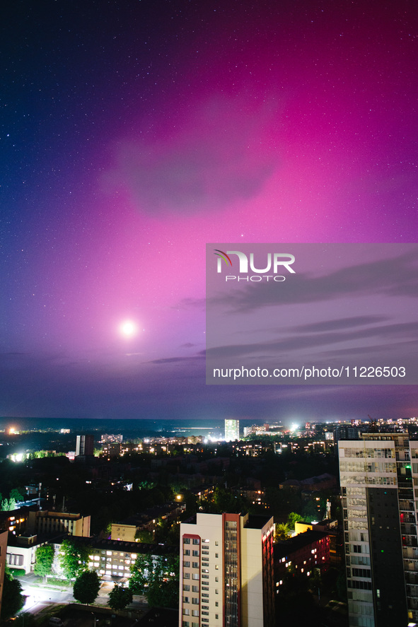 The moon is being illuminated by light reflected from the Earth and is surrounded by the northern lights, in Kharkiv, Ukraine, on May 10, 20...