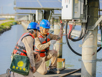 Employees of State Grid Fuzhou Power Supply Company are testing photovoltaic equipment in Xincuo town, Fuqing city, Fujian province, China,...