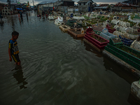 Children are playing at a public cemetery submerged by tidal floods in the Belawan area, Medan, Indonesia, on May 11, 2024. (