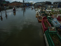 Children are playing at a public cemetery submerged by tidal floods in the Belawan area, Medan, Indonesia, on May 11, 2024. (