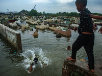 Children are playing at a public cemetery submerged by tidal floods in the Belawan area, Medan, Indonesia, on May 11, 2024. (