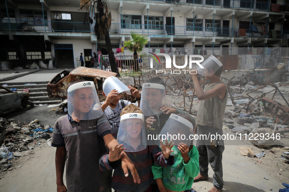 Displaced Palestinian children are playing inside a school where they have taken refuge to set up shelter amid the ongoing conflict between...