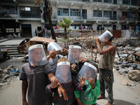 Displaced Palestinian children are playing inside a school where they have taken refuge to set up shelter amid the ongoing conflict between...