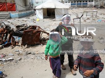 Displaced Palestinian children are playing inside a school where they have taken refuge to set up shelter amid the ongoing conflict between...