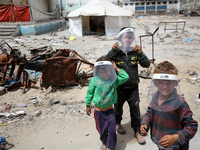 Displaced Palestinian children are playing inside a school where they have taken refuge to set up shelter amid the ongoing conflict between...