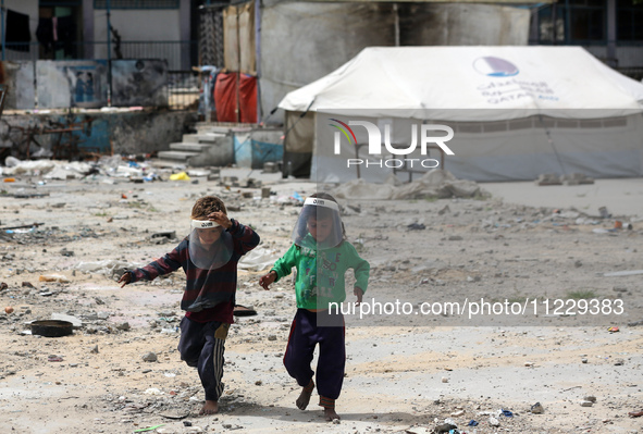 Displaced Palestinian children are playing inside a school where they have taken refuge to set up shelter amid the ongoing conflict between...