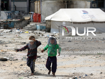 Displaced Palestinian children are playing inside a school where they have taken refuge to set up shelter amid the ongoing conflict between...