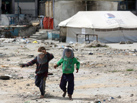 Displaced Palestinian children are playing inside a school where they have taken refuge to set up shelter amid the ongoing conflict between...