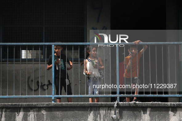 Displaced Palestinian children are playing inside a school where they have taken refuge to set up shelter amid the ongoing conflict between...