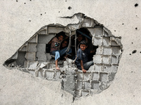 Displaced Palestinian children are playing inside a school where they have taken refuge to set up shelter amid the ongoing conflict between...