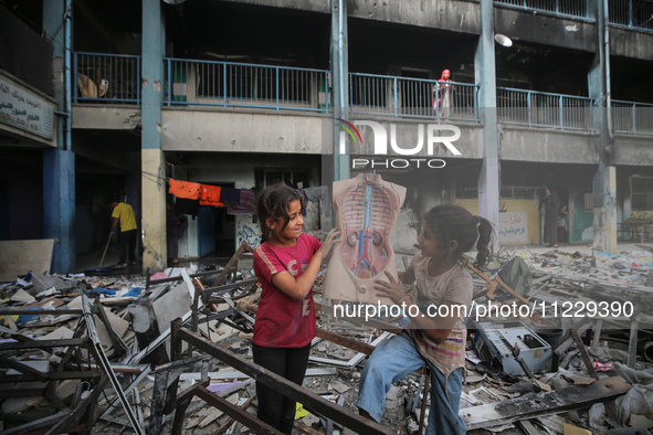 Displaced Palestinian children are playing inside a school where they have taken refuge to set up shelter amid the ongoing conflict between...