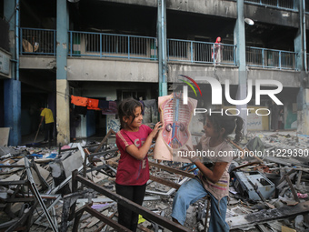 Displaced Palestinian children are playing inside a school where they have taken refuge to set up shelter amid the ongoing conflict between...