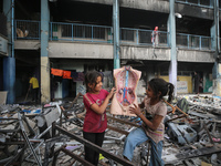 Displaced Palestinian children are playing inside a school where they have taken refuge to set up shelter amid the ongoing conflict between...