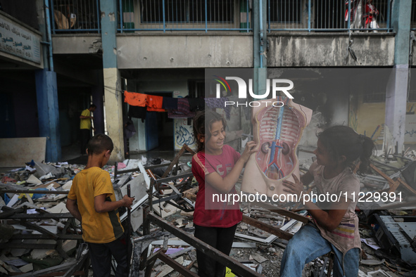 Displaced Palestinian children are playing inside a school where they have taken refuge to set up shelter amid the ongoing conflict between...