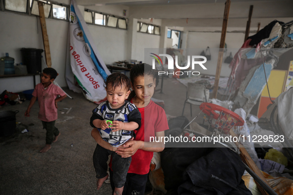 Displaced Palestinians are taking refuge inside a school to set up shelter amid the ongoing conflict between Israel and the Palestinian mili...