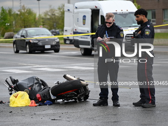 Police are examining evidence at the crash site while the motorcycle is lying on the roadway. A motor vehicle crash involving a Nissan Rogue...