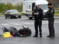 Police are examining evidence at the crash site while the motorcycle is lying on the roadway. A motor vehicle crash involving a Nissan Rogue...